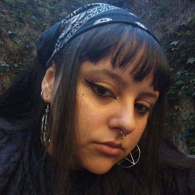 Foto de una mujer de alrededor de 23 años, con pelo negro y flequillo.