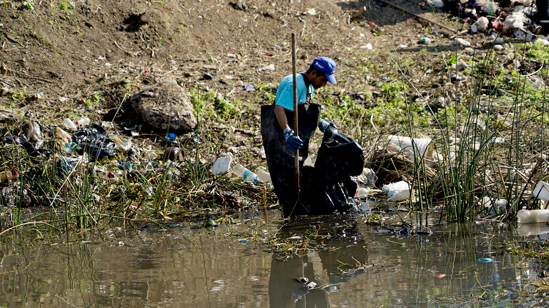 Foto de gente recolectando basura en el río