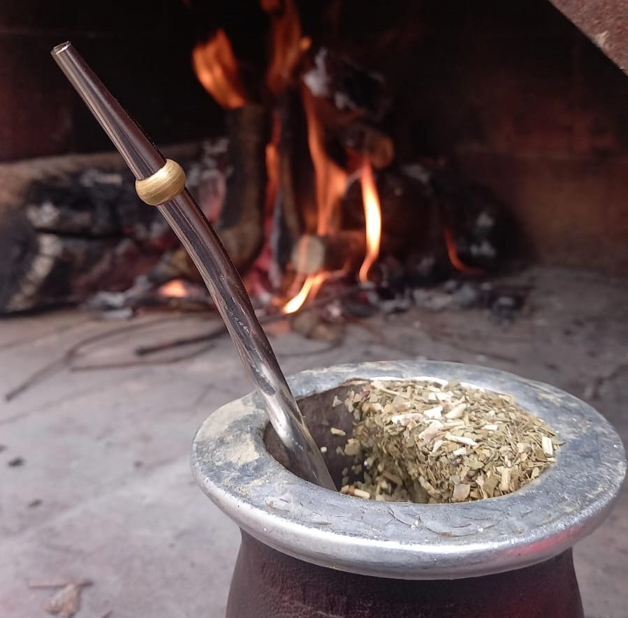 foto de un mate al lado del asado